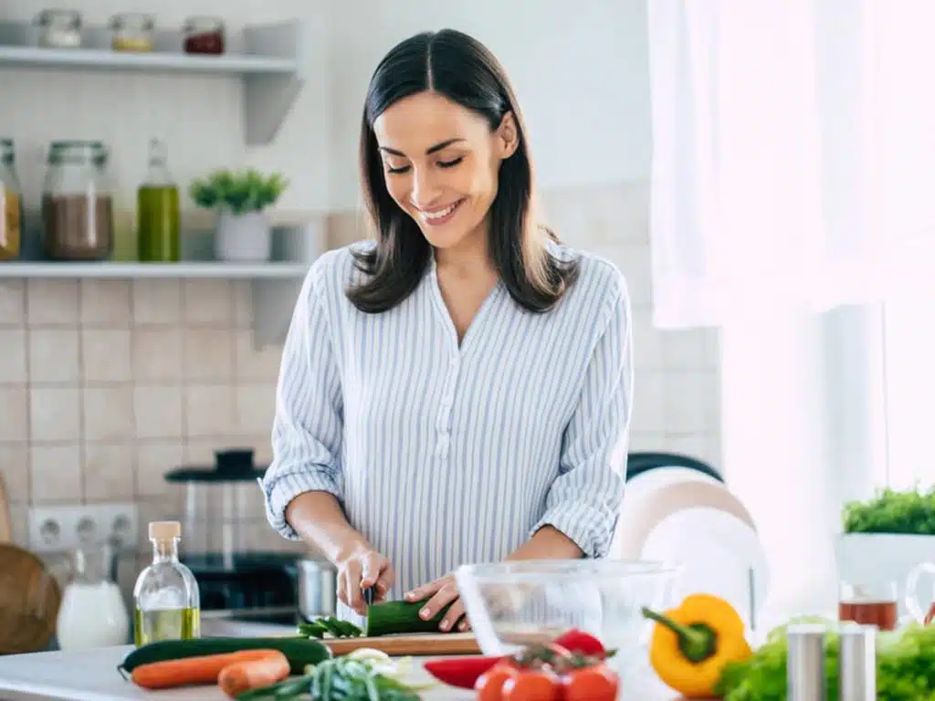 A woman slicing vegetables in a nice kitchen