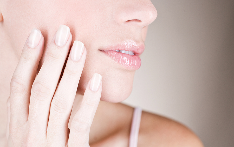 Close-up of a woman's lower face showing smooth skin, defined chin, and natural lip contours for facial balance