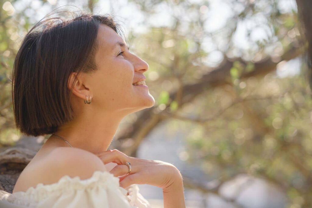 Woman smiling outdoors illustrating natural aging and facelift timing consultation in Beverly Hills.